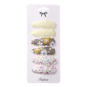 Detail of 6-piece embroidered fabric hair clips set with floral and lace patterns