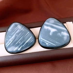 Detail view of vintage resin triangle studs with blue marbling and black frames