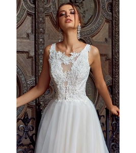 Détail de la dentelle florale blanche avec perles sur la robe de mariée à col en V