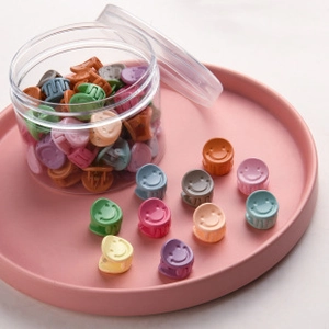 Mini macaron butterfly hair clips with smiley face designs in a clear storage container