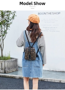 Brown monogram mini backpack on model in outdoor setting with striped shirt and denim