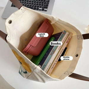 Top view of canvas tote bag interior showing large capacity for books and lunch box