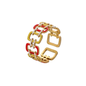 Detailed view of adjustable gold chain ring with red, yellow, and white enamel drip design