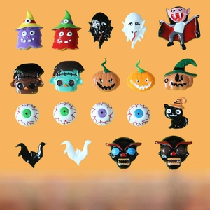 Flat lay of assorted Halloween resin charms featuring ghosts and pumpkins for DIY crafts
