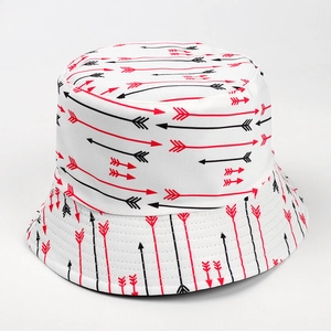 Close-up of reversible bucket hat featuring geometric red and black arrow print pattern