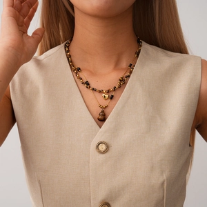 Détail du collier plaqué or 18 carats avec perles œil de tigre et pendentifs cœur et gourde