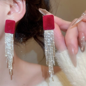 Dettaglio di orecchini quadrati in velluto bordeaux con lunghe nappe di diamanti argento