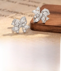 Macro detail of silver butterfly earrings with cubic zirconia and steel flat back