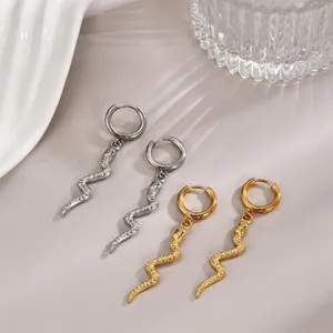 Elegant gold and silver snake hoop earrings featuring green stone eyes and textured scales