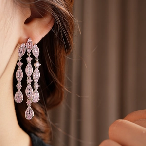 Close-up of elegant long tassel earrings with pink zircon water drop pendant on a model