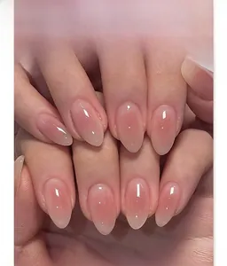 Close-up of pink gradient almond press-on nails with a glossy jelly finish and soft luster
