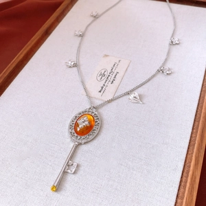 Macro shot of silver vintage key pendant with amber resin stone and floral design