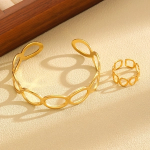 Artistic shadow play on golden hollow geometric jewelry set with ring and open bangle