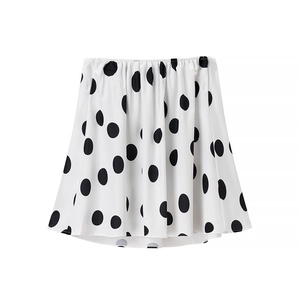 Détail d'une mini-jupe blanche à pois noirs avec taille élastique et texture satinée