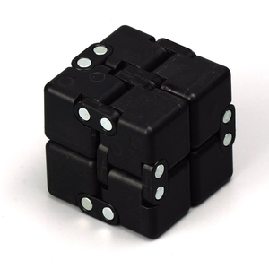 Close-up of black stress relief infinity cube with metal hinges on white background