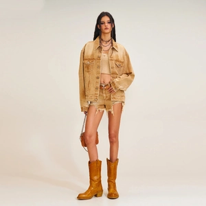 Detailed close-up of distressed tan denim jacket with metallic buttons and frayed edges