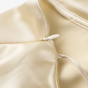 Close-up of champagne satin fabric showing fine stitching and seamless invisible zipper