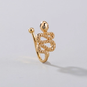 Macro detail of a golden snake nose cuff with crystal eyes and textured metal finish