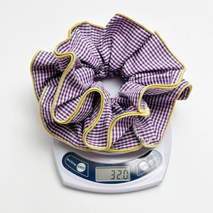 Oversized purple plaid scrunchie with yellow trim on a scale weighing 32.0 grams