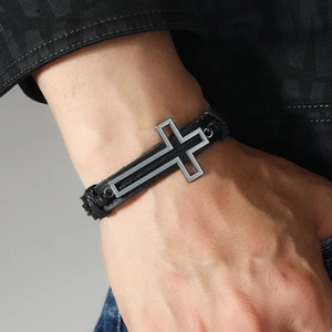 Handmade woven black leather bracelet for men featuring a vintage silver cross charm