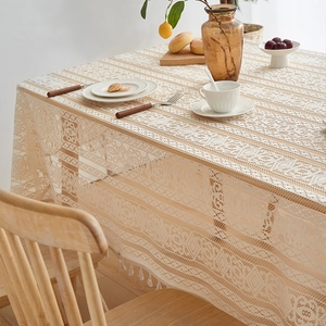 Detail of beige lace tablecloth with delicate floral patterns and decorative tassels