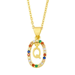 Detailed macro view of gold oval pendant with multicolor stones and capital letter Q