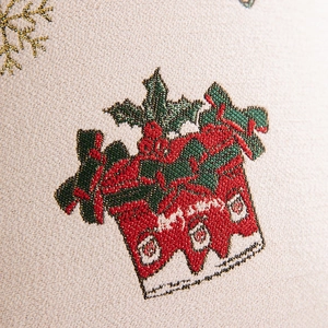 Detail of embroidered Christmas gift box with holly leaves and golden snowflakes on fabric