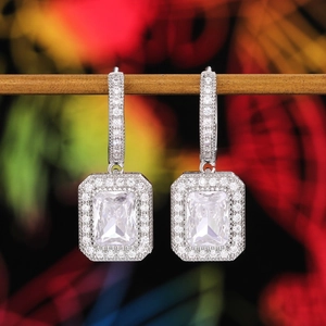 Detailed close-up of silver leverback earrings with princess cut crystals and halo pavé setting