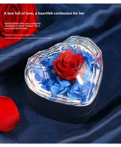 Detail view of heart-shaped box with red preserved rose and acrylic cover on blue silk