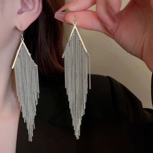 Detail of silver long tassel earrings with triangular metal pieces on model