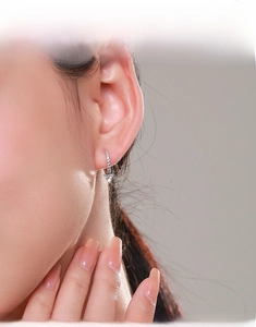 Detailed view of S925 silver V-shaped drop earrings with sparkling diamonds on a model