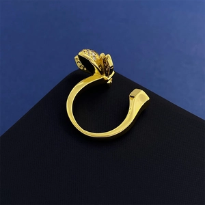 Detail of a gold butterfly ring with clear crystals on a geometric background