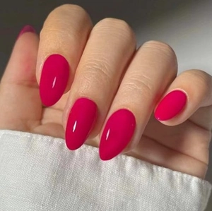 Vue macro de faux ongles ovales magenta brillants avec une finition lisse et polie