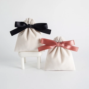 Close-up of cream velvet drawstring jewelry pouches with elegant satin bow details