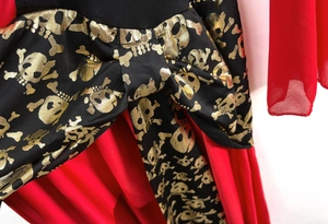 Detail view of pirate costume with golden skull print on black satin and red pleated skirt