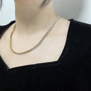 Close-up of gold-plated tennis necklace with sparkling cubic zirconia on a model