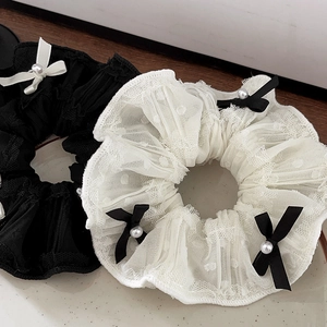 Detail of lace scrunchies with bow and pearl accents in black and cream white colors