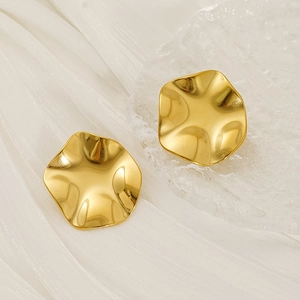 Exaggerated gold wavy round stud earrings in stainless steel on white silk background