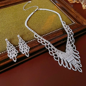 Close-up of sparkling rhinestone necklace and earrings set on vintage wooden tray