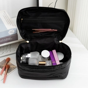 Interior view of black quilted cosmetic bag with dual zippers and mesh pocket storage