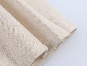 Detailed macro view showing the natural beige linen fabric texture and weave pattern