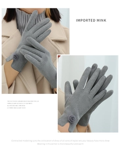 Detail view of grey winter gloves featuring imported mink fur and decorative pom-poms