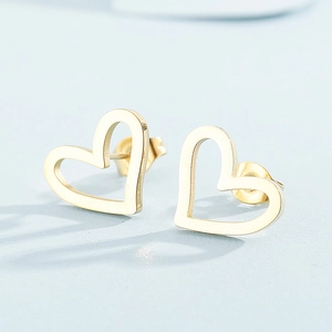 Macro view of minimalist hollow heart stud earrings in golden finish with backings