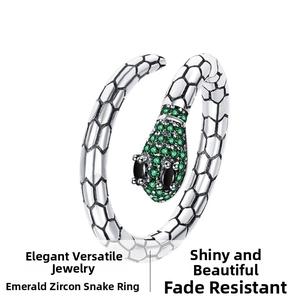 Macro detail of silver snake ring featuring green emerald zircon and scaled texture