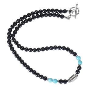 Detail of beaded necklace with blue turquoise accents, black beads and silver OT clasp