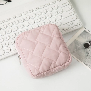 Gros plan d'une trousse à maquillage rose matelassée avec fermeture éclair argentée