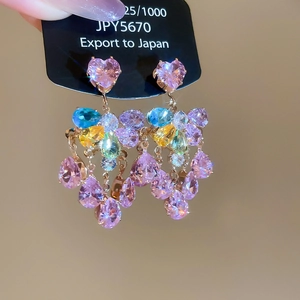 Detailed close-up of sparkling heart and colorful pear-cut zircon tassel earrings