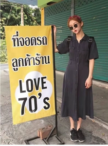 Street style shot of a vintage black short-sleeve midi dress with buttoned collar