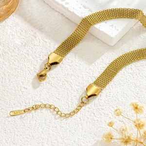 Minimalist gold stainless steel chain necklace with lobster clasp and tag on stone surface