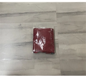 Detailed view of red Christmas stocking gift bag folded in transparent plastic packaging